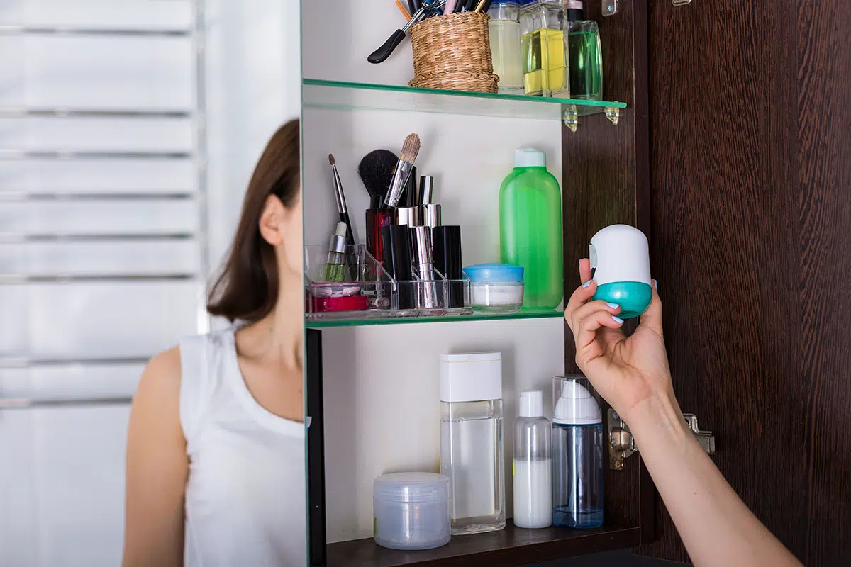 Woman checking her skincare products in cabinet